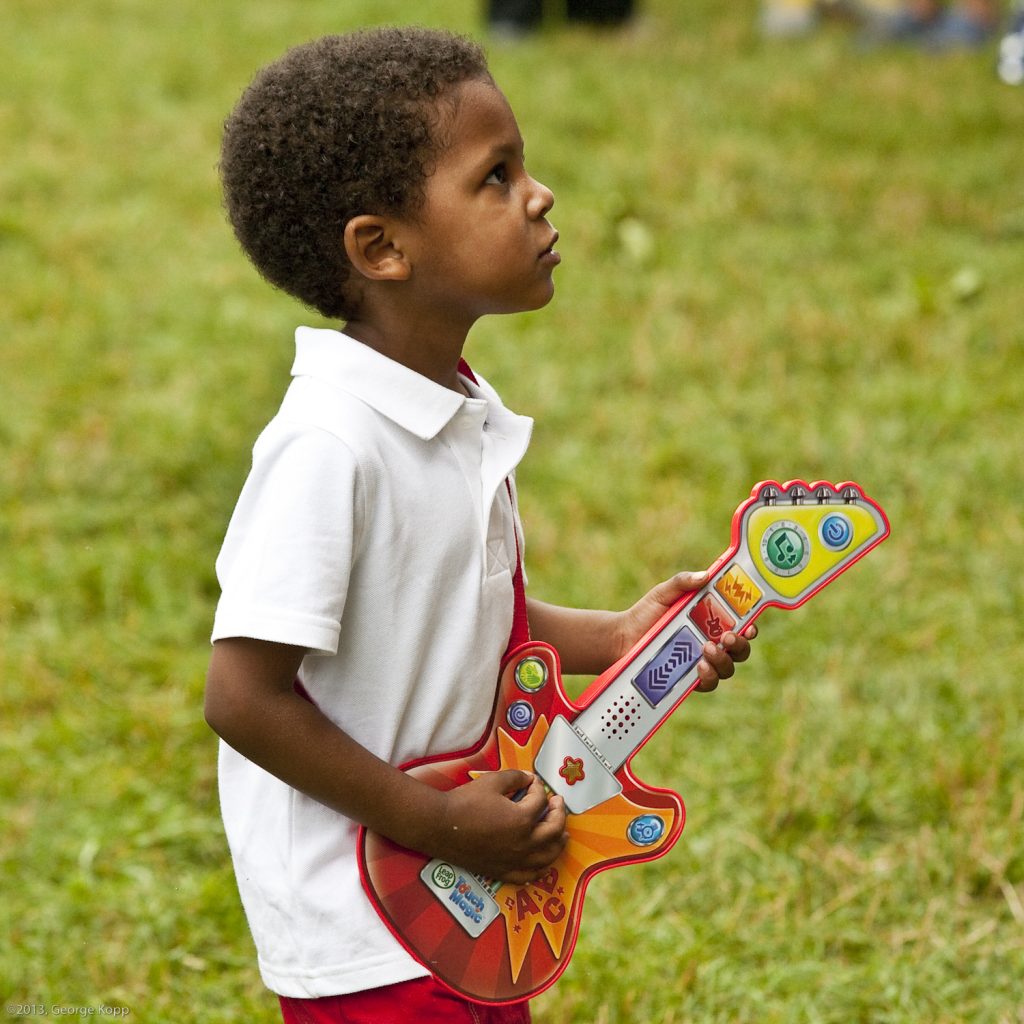 kid playing toy guitar